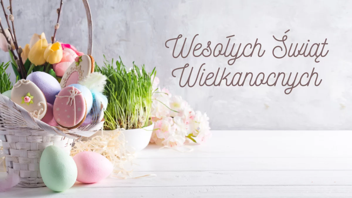 Wesołych Świąt Wielkanocnych. Koszyk z kolorowymi jajkami. W tle zielona roślina wyglądem przypominająca trawę.