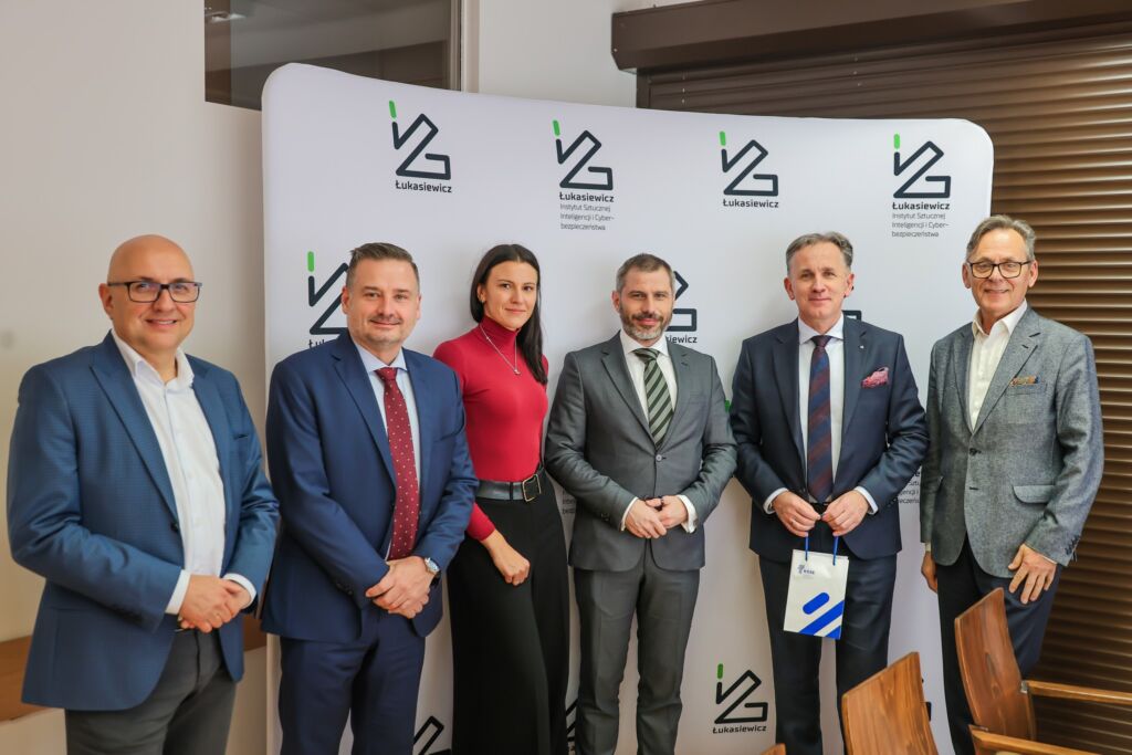 Grupa 4 mężczyzna w garniturach i 1 kobieta.