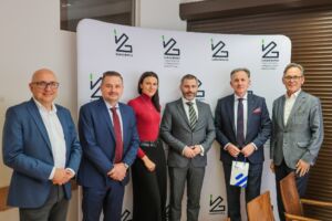 Grupa 4 mężczyzna w garniturach i 1 kobieta.