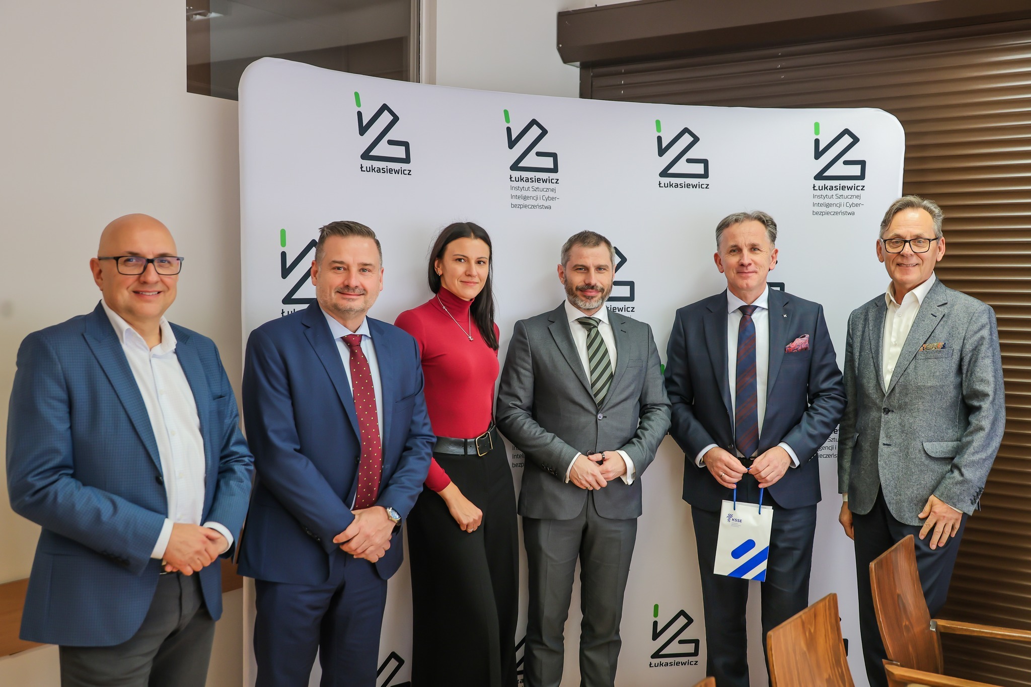 Grupa 4 mężczyzna w garniturach i 1 kobieta.