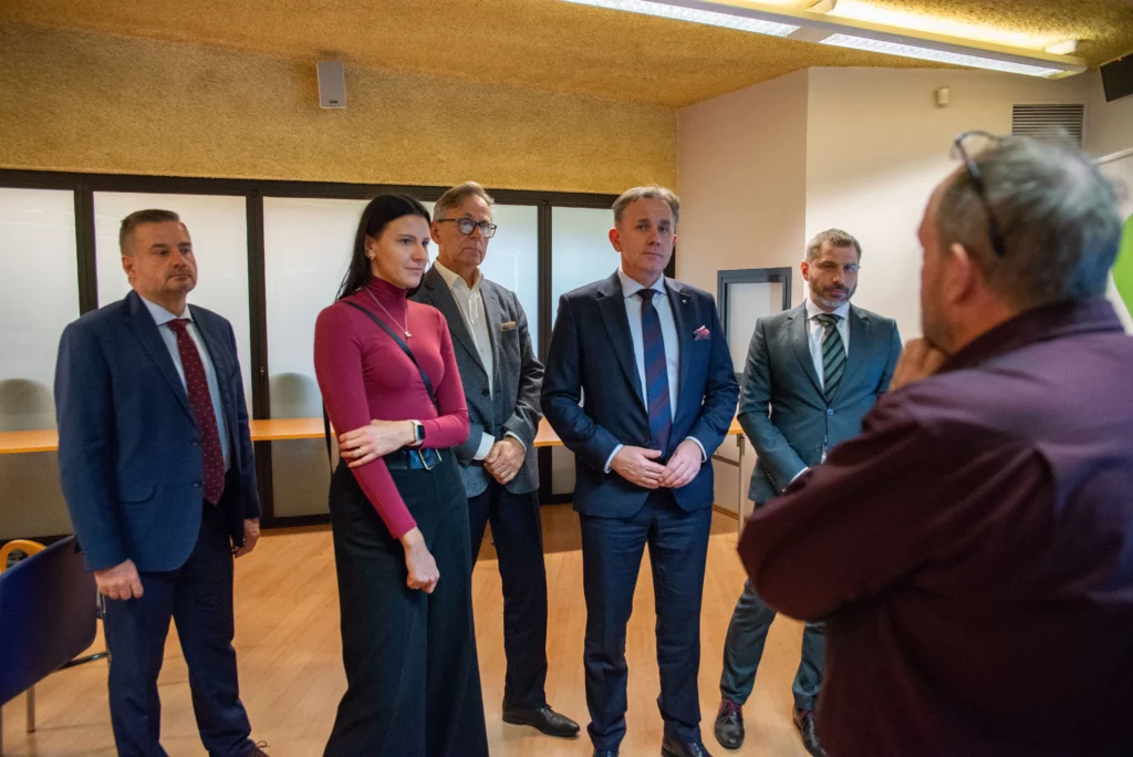 Grupa kilku dorosłych w dużym oświetlonym pomieszczeniu