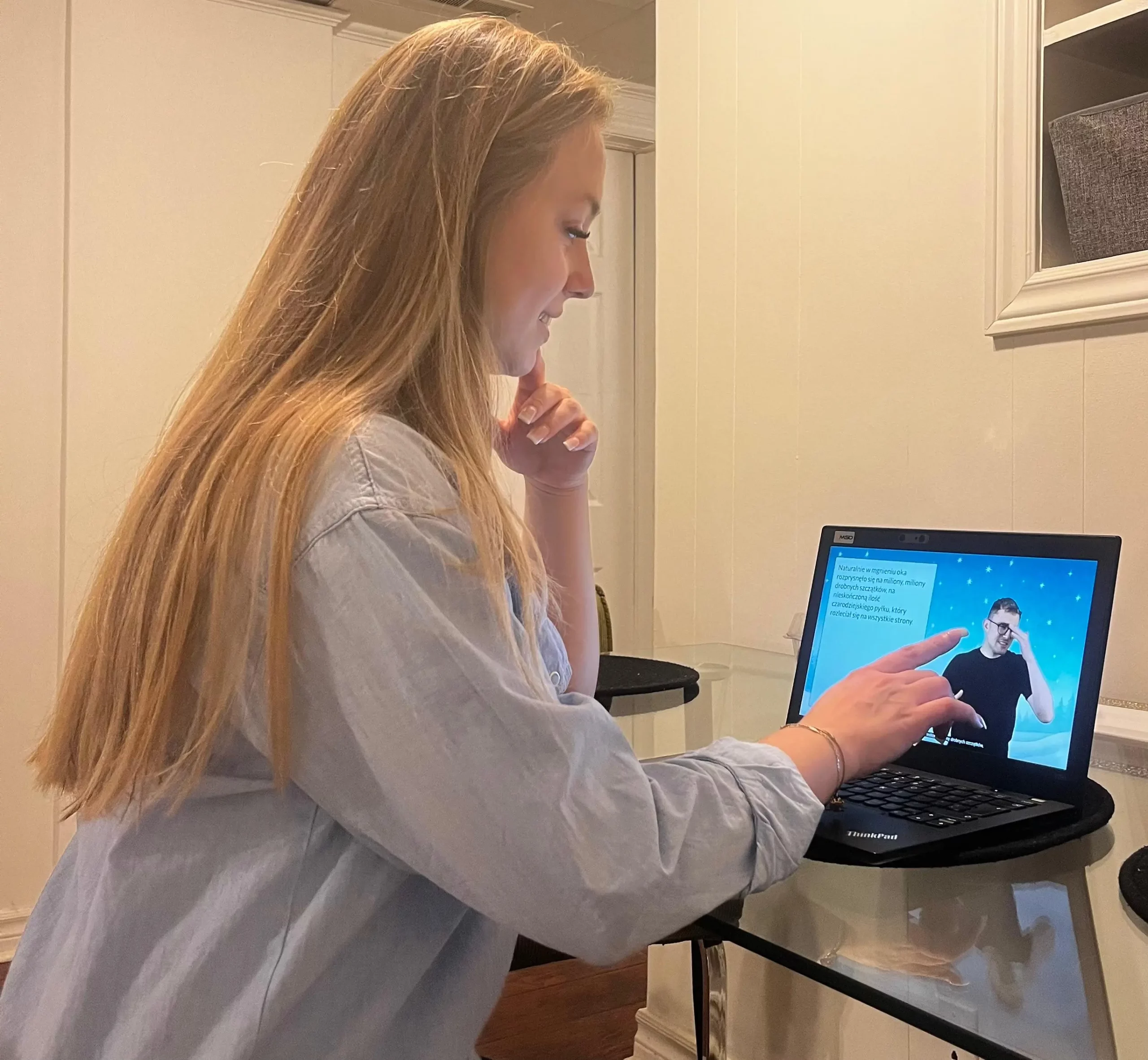 Kobieta przy laptopie spogląda na prezentowaną treść