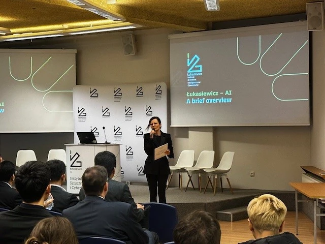 Kobieta na dużej sali przemawia do mikrofonu