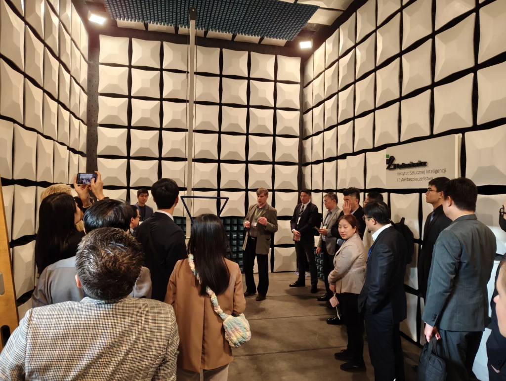 Grupa osób w bardzo wysokim pomieszczeniu wyłożonym płytkami 3d