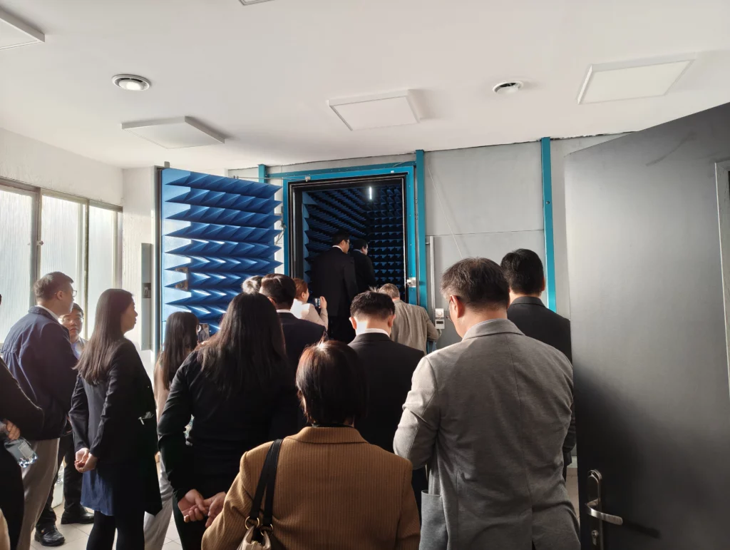 grupa osób wchodzi do pomieszczenia przez nietypowe drzwi