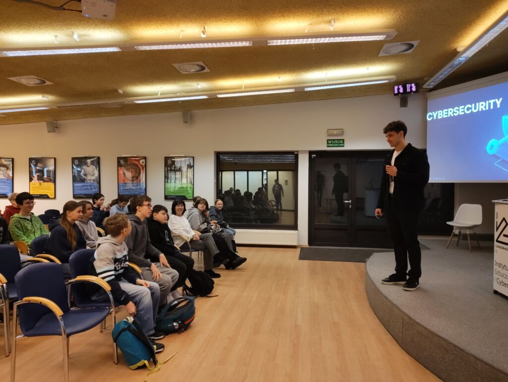 Mężczyzna na scenie. Przed nim słuchacze.