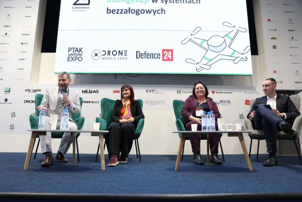 Four people sitting on stage.