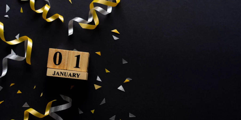 01 January na kostkach drewnianych. W tle konfetti.