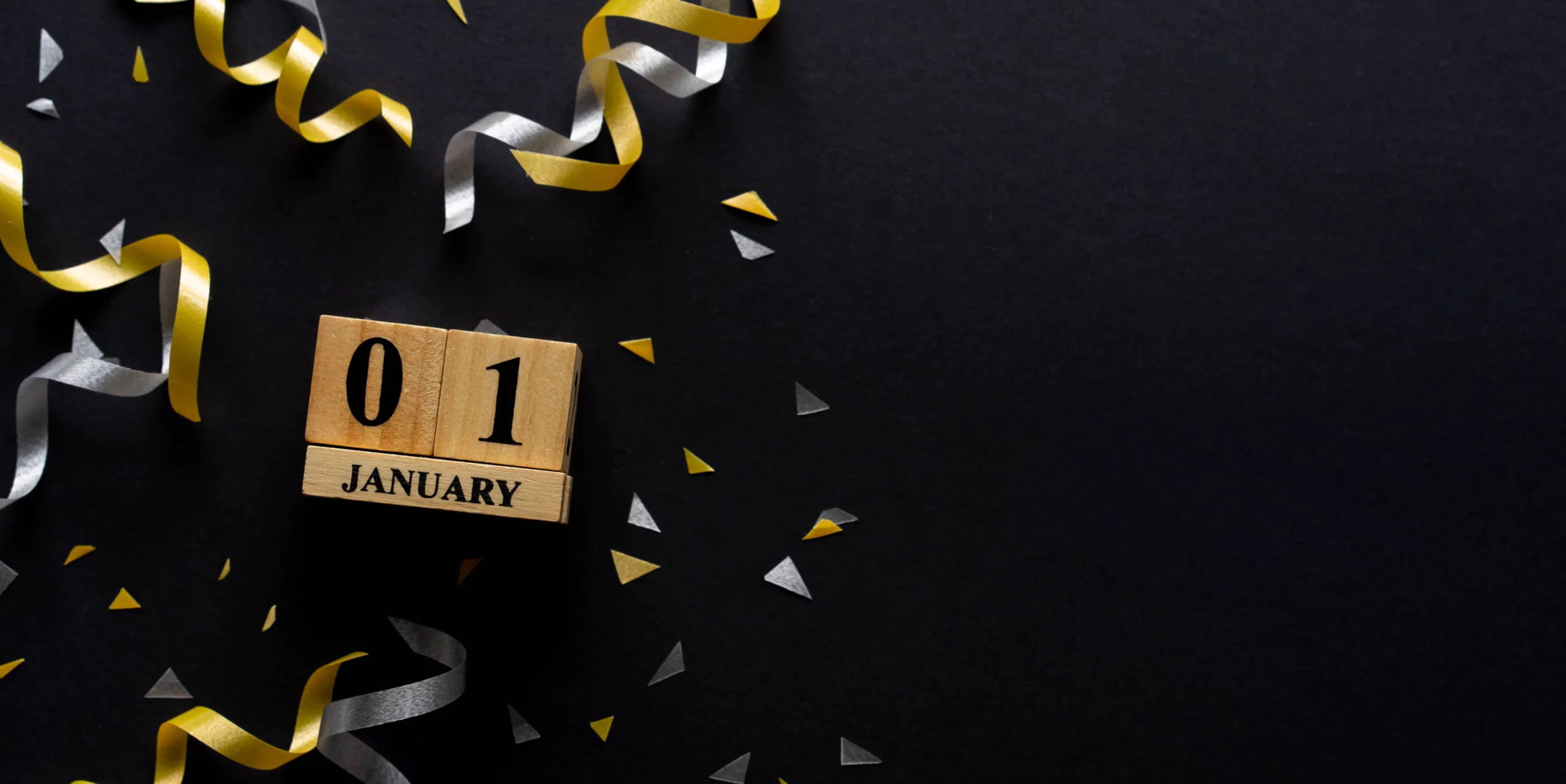 01 January na kostkach drewnianych. W tle konfetti.